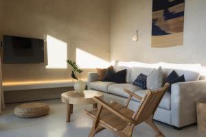 una sala de estar con un sofá, una mesa y sillas en RAKSA Villas, en Ban Madua Wan