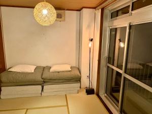 御殿場市にあるFUJI Forest House203の窓のある部屋にソファが備わる部屋