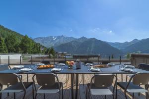 - une table sur une terrasse avec vue sur les montagnes dans l'établissement TERRESENS - Le Quartz - NEW, à Peisey-Nancroix