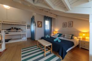 ein Schlafzimmer mit einem Bett und zwei Etagenbetten in der Unterkunft Capricho de Rovacias, Comillas, Cantabria in Comillas + 35 Fotos