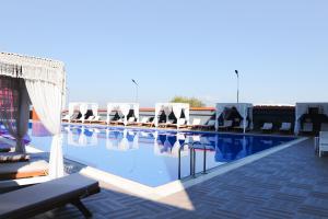 a swimming pool with a bunch of lounge chairs at Adler Apartments in Prizren