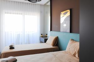 a bedroom with two beds and a window at Adler Apartments in Prizren +17 photos