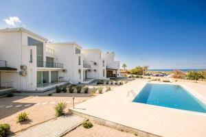 ein großes Haus mit einem Pool am Meer in der Unterkunft Spacious Three-Bedroom Apartment A3 in Sanctuary Cove site in Kyrenia