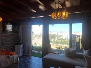 a living room with a couch and a large window at Rooftop terasse azur essaouira in Essaouira