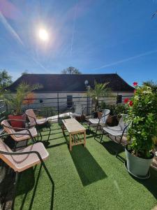 un patio con sillas, mesas y macetas en Amadour Hôtel, en Rocamadour