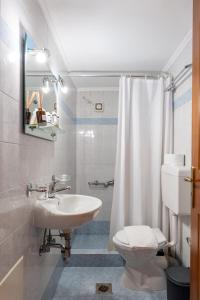 a bathroom with a sink and a toilet and a shower at Mountain Hotels "Aroanides" in Planitéron