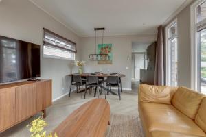 una sala de estar con un sofá y una mesa en Natuurhuisje Hellendoorn met luxe Hottub, en Haarle