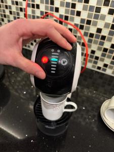 una mano sostiene una cafetera en Rimlige rom-kortidsleie, 