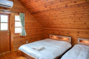 a bedroom with two beds in a wooden cabin at Sakata Log House - Vacation STAY 32306v in Sakata