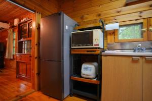 a kitchen with a stainless steel refrigerator and a microwave at Sakata Log House - Vacation STAY 32306v in Sakata