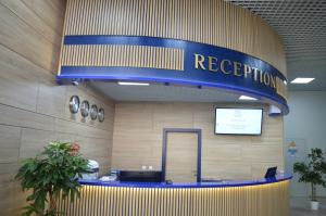 an airport lobby with a reception desk and a sign at Triumph Hotel in Obninsk