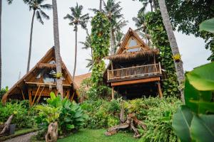 a resort with palm trees in the background at Batu Kayu Medewi in Medewi