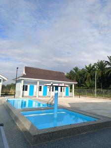 a house with a blue pool in front of it at Villa Atok Opah in Teluk Intan +31 photos