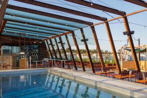 a pool on the roof of a building with tables and chairs at The Winery Hotel, WorldHotels Crafted in Solna