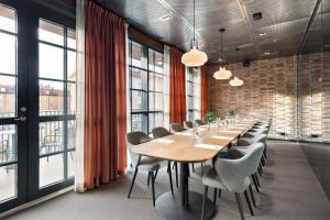 a long table and chairs in a room with windows at The Winery Hotel, WorldHotels Crafted in Solna +88 photos