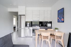 a kitchen and dining room with a table and chairs at Hiisi Homes Sipoo Söderkulla in Söderkulla