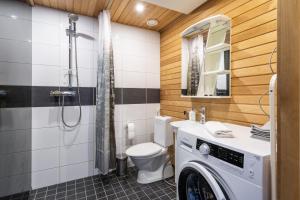 a bathroom with a toilet and a washer and dryer at Hiisi Homes Sipoo Söderkulla in Söderkulla +31 photos