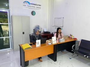 two women sitting at a desk with their laptops at BMC HomeStay in Sebungsungai