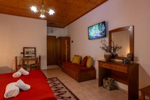 a bedroom with a red bed and a mirror at Mountain Hotels "Aroanides" in Planitéron