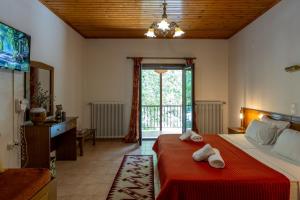 a bedroom with a large bed with towels on it at Mountain Hotels "Aroanides" in Planitéron