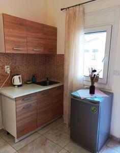 una piccola cucina con un lavandino e una finestra di Ζ&Ζ Studios a Perea Altre 32 foto