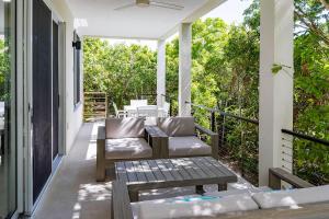 a porch with a couch and chairs on a house at Wyakha 1 Garden View in Long Bay Hills