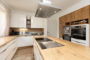 a kitchen with white cabinets and a wooden counter top at Villa Hietzing in Vienna