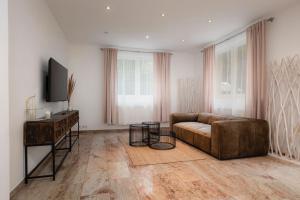 a living room with a couch and a flat screen tv at Villa Hietzing in Vienna