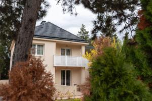 a white house with a balcony and a tree at Villa Hietzing in Vienna