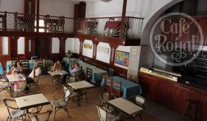 een restaurant met tafels en stoelen en mensen aan tafel bij Royal Mindelo Suite in Mindelo