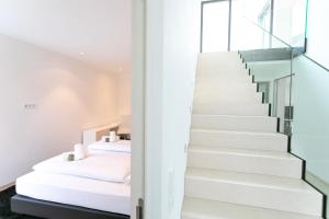 a bedroom with white walls and stairs with a bed at Villa Shangrila - Alpstay in Naturno