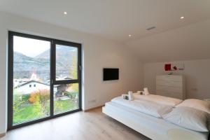 a bedroom with a bed and a large window at Villa Shangrila - Alpstay in Naturno