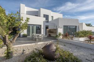 a white house with a courtyard in front of it at Villa Elite Maribiza in Cala Llenya
