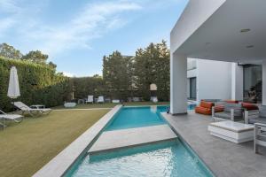 a swimming pool in the backyard of a house at Villa Elite Maribiza in Cala Llenya