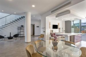 a dining room and living room with a glass table and chairs at Villa Elite Maribiza in Cala Llenya