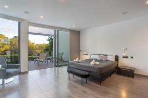 a bedroom with a bed and a living room at Villa Elite Maribiza in Cala Llenya +24 photos