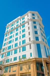a white building with blue windows on top of it at Kingdom Hotel Cua Lo in Cửa Lò