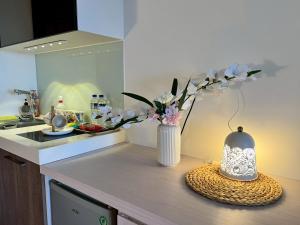 uma cozinha com um vaso de flores num balcão em 漫遊文旅溫泉宅ㄧ山海景觀陽台房ㄧ晚上6點入住ㄧ晚進晚退一21小時睡飽飽方案 em Toucheng