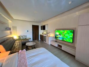 uma sala de estar com um sofá e uma TV de tela plana em 漫遊文旅溫泉宅ㄧ山海景觀陽台房ㄧ晚上6點入住ㄧ晚進晚退一21小時睡飽飽方案 em Toucheng