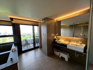 um banheiro com uma pia e um espelho grande em 漫遊文旅溫泉宅ㄧ山海景觀陽台房ㄧ晚上6點入住ㄧ晚進晚退一21小時睡飽飽方案 em Toucheng mais 20 fotografias