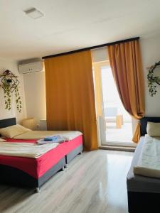 Dobrinjeにある3D Caffe Apartmaniのベッドが2つと大きな窓がある寝室