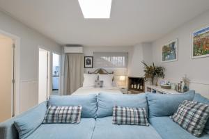 a living room with a blue couch and a bed at Host Dalies in San Pedro de Premiá +22 photos