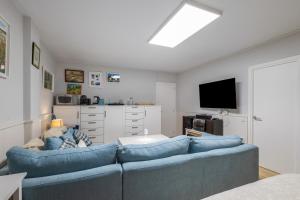 a living room with a blue couch and a tv at Host Dalies in San Pedro de Premiá