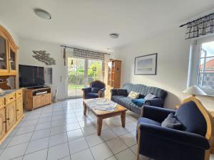Nordseeferienhaus Ehlers في نيسمارزييل: غرفة معيشة مع أرائك وطاولة قهوة