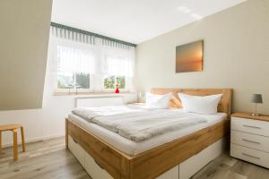 a bedroom with a large bed with white sheets at Jagdhaus Prerowstrom in Jagdhaus