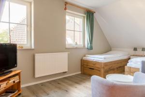 a small room with two beds and a tv at Jagdhaus Prerowstrom in Jagdhaus