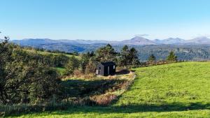 a small cabin on a hill with mountains in the background at Ascella in Llanrwst +22 photos