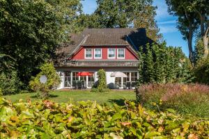 a red and white house with a yard at Jagdhaus Prerowstrom in Jagdhaus