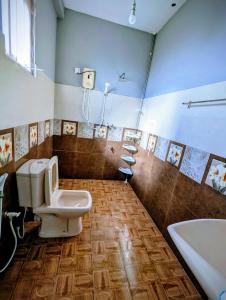 a bathroom with a toilet and a sink and a tub at Costels Coconut hill in Mirissa