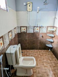 a bathroom with a toilet and a shower at Costels Coconut hill in Mirissa